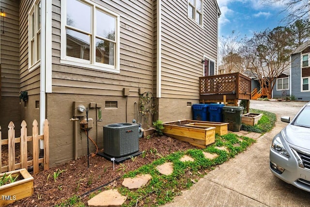 view of property exterior featuring a vegetable garden and central AC unit