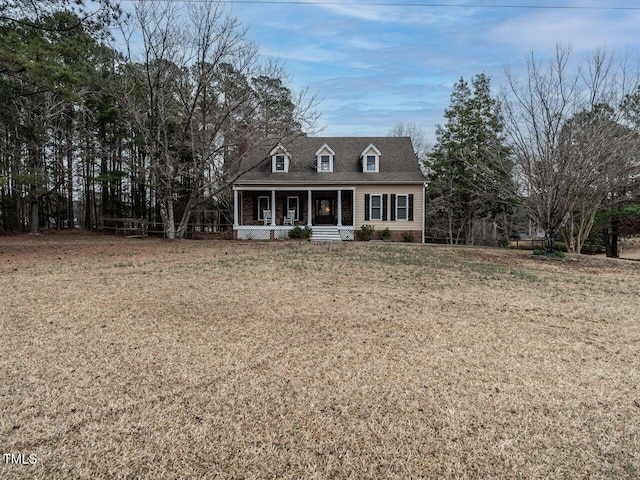 cape cod home featuring a porch and a front yard