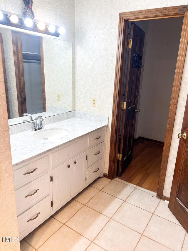 bathroom featuring a walk in closet, vanity, and tile patterned floors