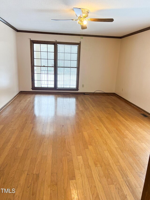 unfurnished room with ornamental molding, baseboards, visible vents, and light wood finished floors