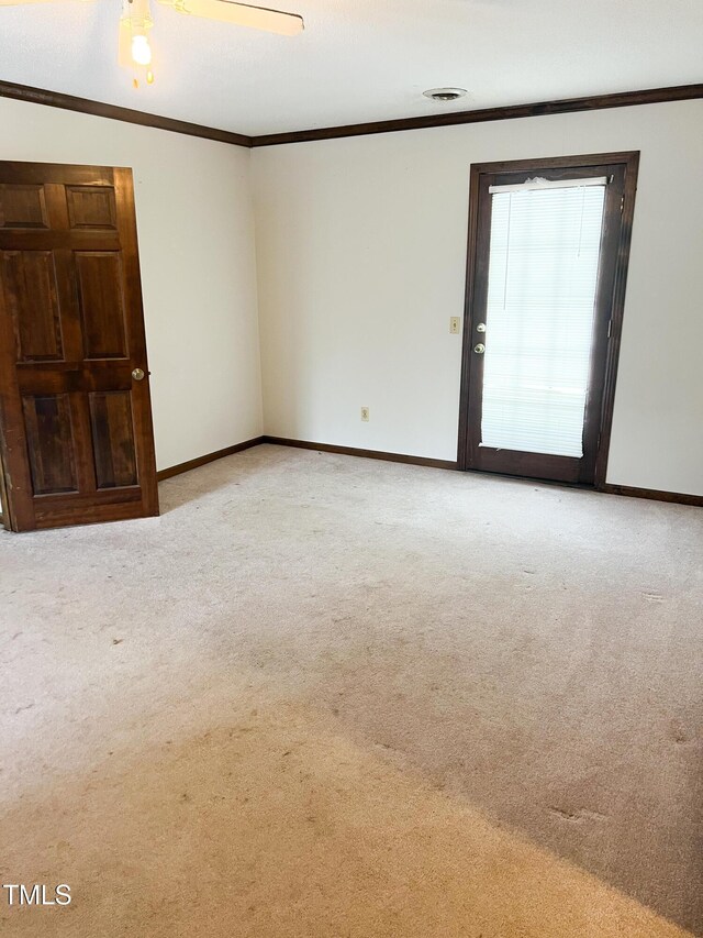 spare room with ornamental molding, light carpet, and baseboards