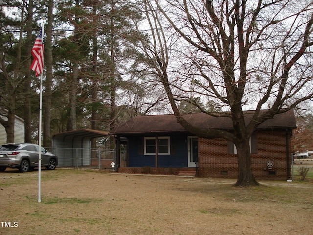 ranch-style home featuring a detached carport, roof with shingles, crawl space, a front yard, and brick siding