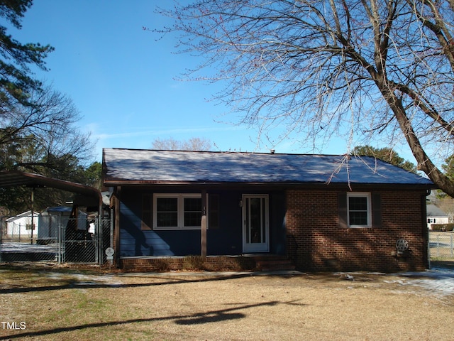 view of front of property featuring entry steps, fence, and brick siding