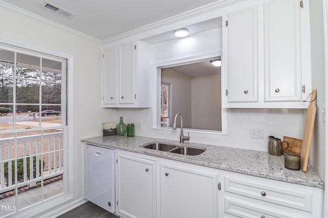 kitchen featuring white dishwasher, white cabinets, and a sink