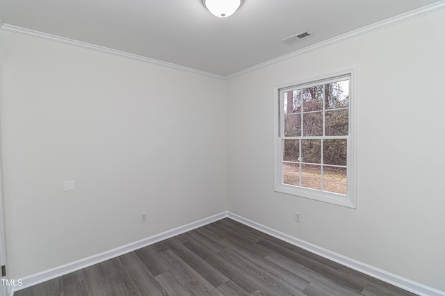 empty room featuring dark wood-style floors, a healthy amount of sunlight, visible vents, and baseboards