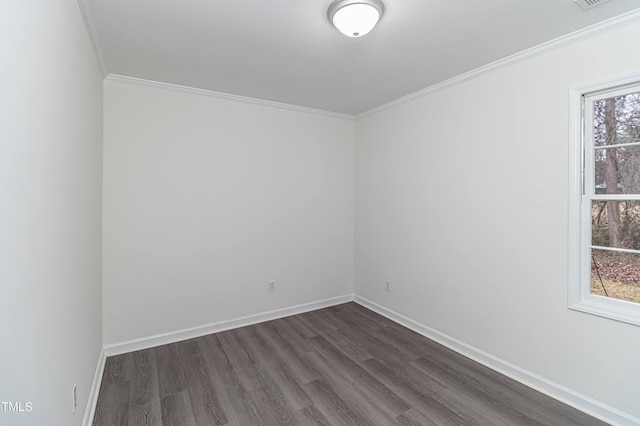 empty room featuring plenty of natural light, ornamental molding, dark wood finished floors, and baseboards