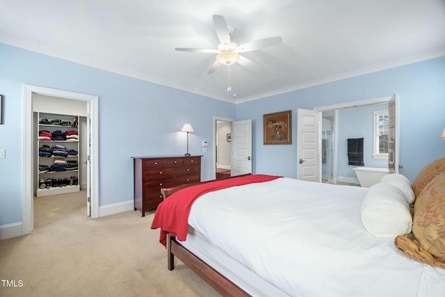 bedroom featuring a walk in closet, a closet, ornamental molding, light carpet, and baseboards