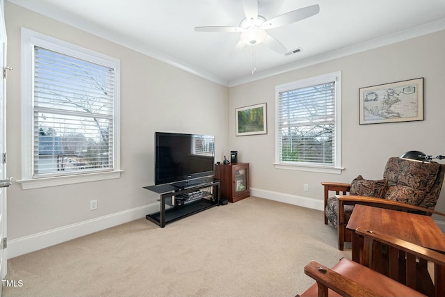 sitting room with light colored carpet, crown molding, baseboards, and ceiling fan