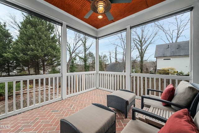 sunroom / solarium featuring wooden ceiling and a ceiling fan