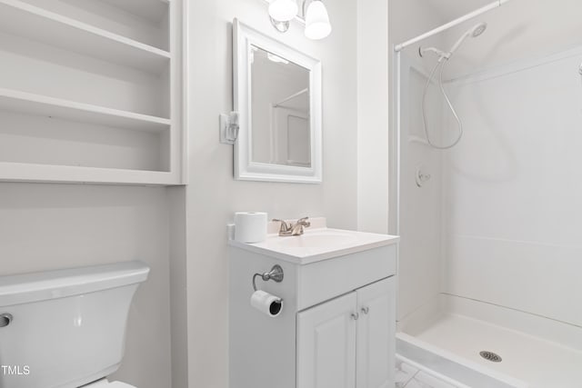 full bathroom featuring a stall shower, toilet, and vanity