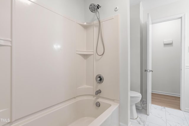 bathroom with marble finish floors, toilet, washtub / shower combination, baseboards, and ornamental molding