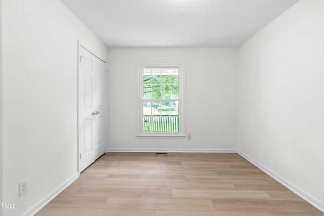 unfurnished bedroom featuring light wood-style flooring and baseboards