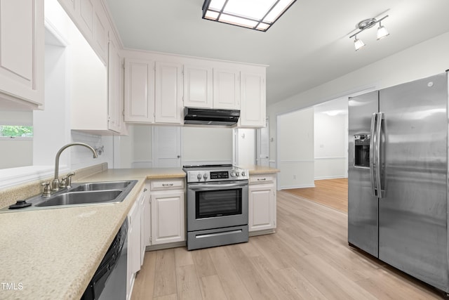 kitchen with appliances with stainless steel finishes, exhaust hood, a sink, light countertops, and white cabinets