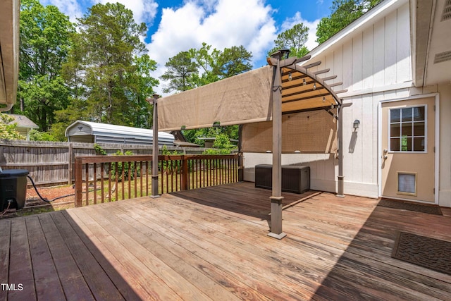wooden deck with a fenced backyard, a pergola, and central AC unit