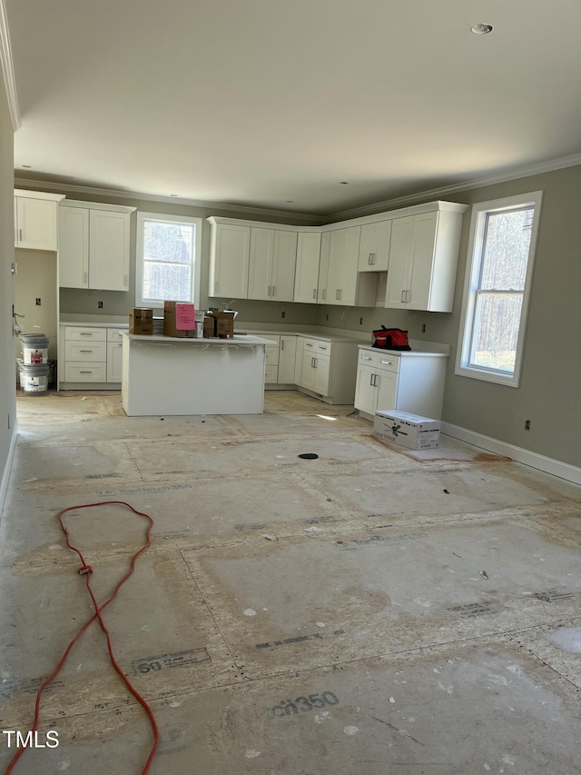 kitchen featuring crown molding, plenty of natural light, baseboards, and a center island