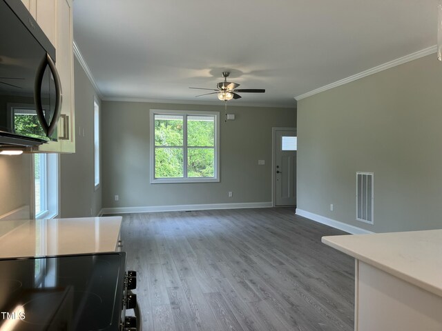 162 Kirkwall Ln, Selma, NC 27576 - unfurnished living room featuring wood finished floors, ceiling fan, baseboards, ornamental molding, and visible vents