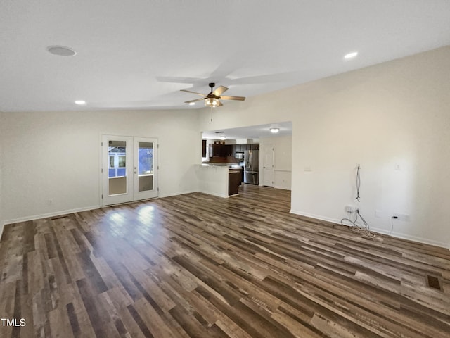 unfurnished living room featuring baseboards, dark wood-style floors, ceiling fan, vaulted ceiling, and french doors