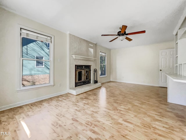 308 Trimble Ave, Cary, NC 27511 - unfurnished living room with healthy amount of natural light, light wood-style flooring, a ceiling fan, and a large fireplace