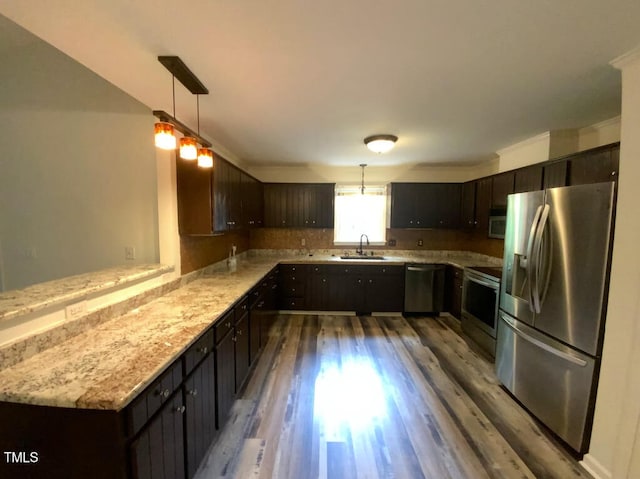 308 Trimble Ave, Cary, NC 27511 - kitchen with stainless steel appliances, wood finished floors, a peninsula, and dark brown cabinetry