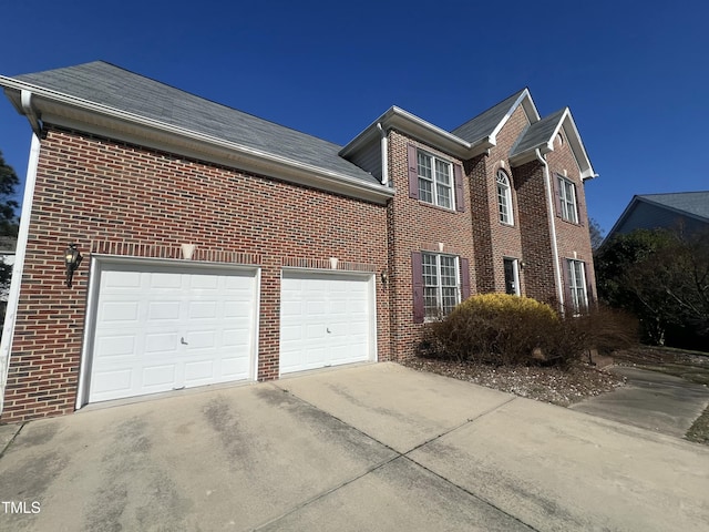 view of property exterior with a garage, concrete driveway, and brick siding