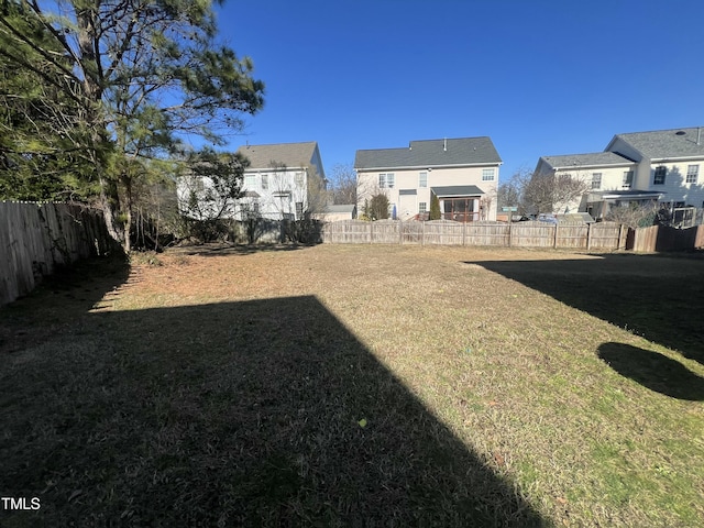 view of yard featuring a fenced backyard and a residential view