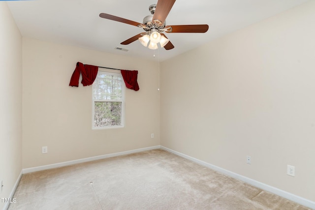 spare room with light carpet, baseboards, visible vents, and ceiling fan