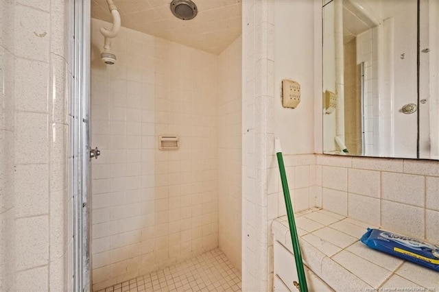 full bath featuring a stall shower and tile walls