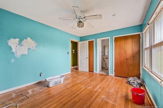 unfurnished bedroom featuring baseboards, ceiling fan, and light wood finished floors