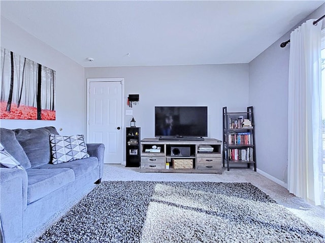 living area featuring baseboards and light colored carpet