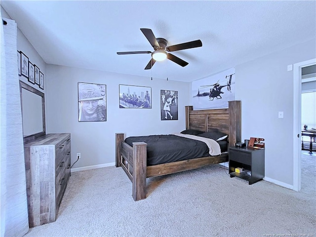 bedroom with light colored carpet, a ceiling fan, and baseboards