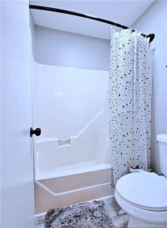 bathroom featuring shower / bath combo with shower curtain, toilet, and wood finished floors