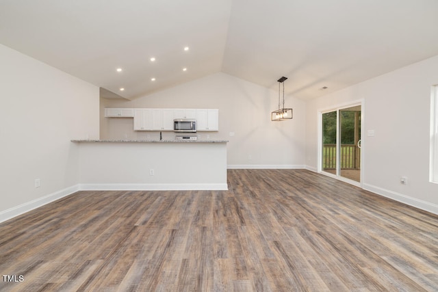 unfurnished living room featuring dark wood-style floors, vaulted ceiling, recessed lighting, and baseboards