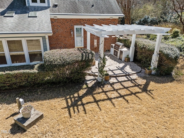 exterior space featuring a patio area, an outdoor kitchen, and a pergola