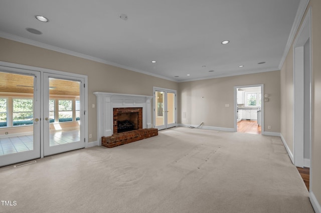 unfurnished living room featuring ornamental molding, french doors, light colored carpet, and baseboards