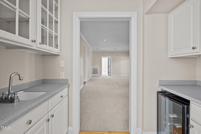 bar featuring baseboards, light colored carpet, wine cooler, a sink, and recessed lighting