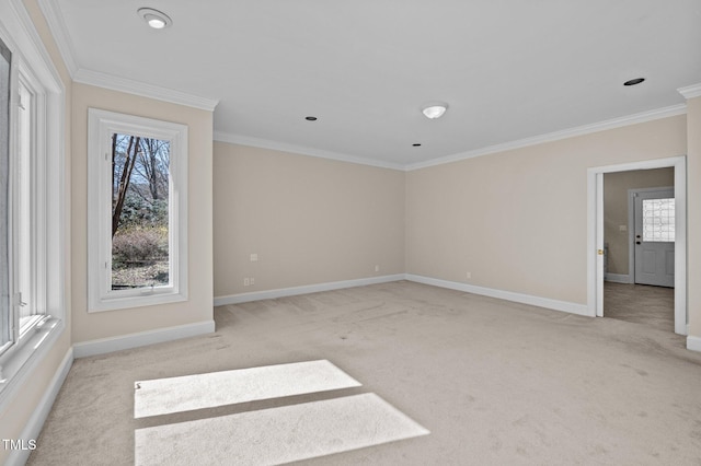 spare room featuring ornamental molding, light carpet, and baseboards