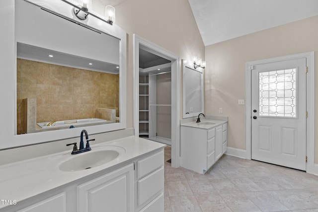 bathroom with a garden tub, two vanities, a sink, and tile patterned flooring