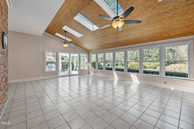 empty room featuring a skylight, wood ceiling, light tile patterned flooring, and brick wall