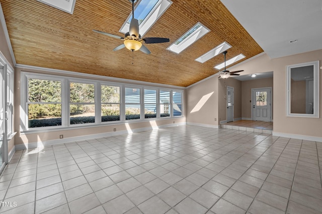 interior space with light tile patterned floors, vaulted ceiling with skylight, ceiling fan, wood ceiling, and baseboards