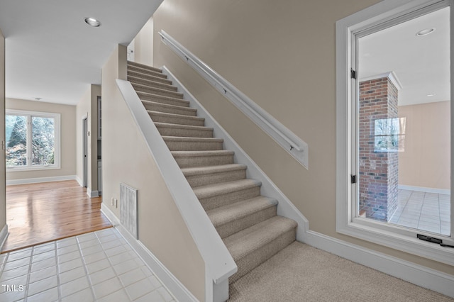 stairway with baseboards, recessed lighting, visible vents, and tile patterned floors