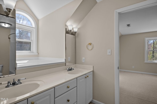 full bath with vaulted ceiling, visible vents, a sink, and a wealth of natural light