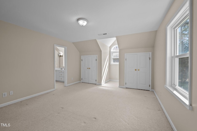 bonus room with light carpet, plenty of natural light, visible vents, and baseboards