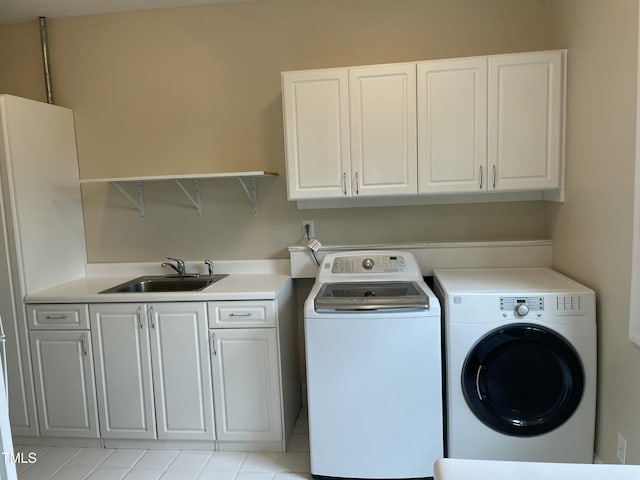 washroom with washer and dryer, cabinet space, and a sink