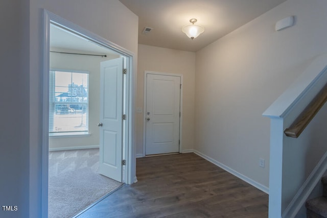 corridor with dark wood finished floors, stairway, and baseboards