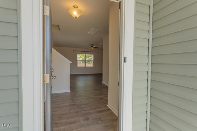 hallway featuring dark wood finished floors and baseboards