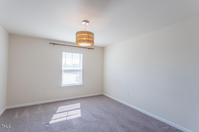 spare room with carpet and baseboards