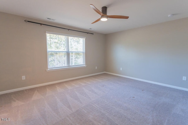 unfurnished room featuring light carpet, baseboards, visible vents, and a ceiling fan