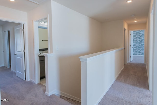 hallway with baseboards, carpet floors, an upstairs landing, and recessed lighting