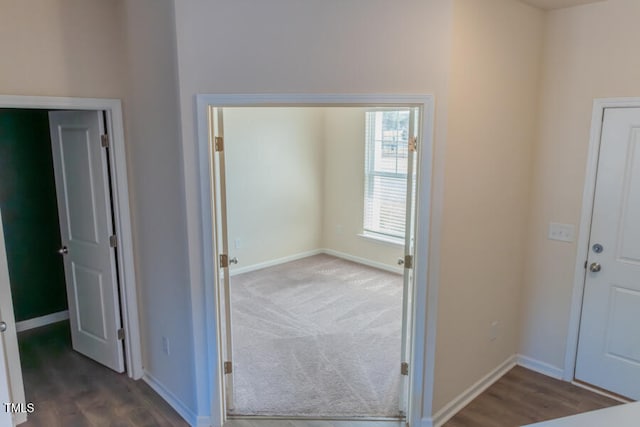 carpeted foyer entrance featuring wood finished floors and baseboards