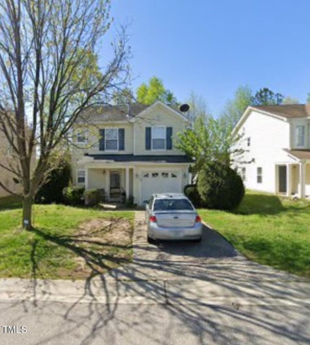 traditional-style home featuring a garage, concrete driveway, and a front lawn